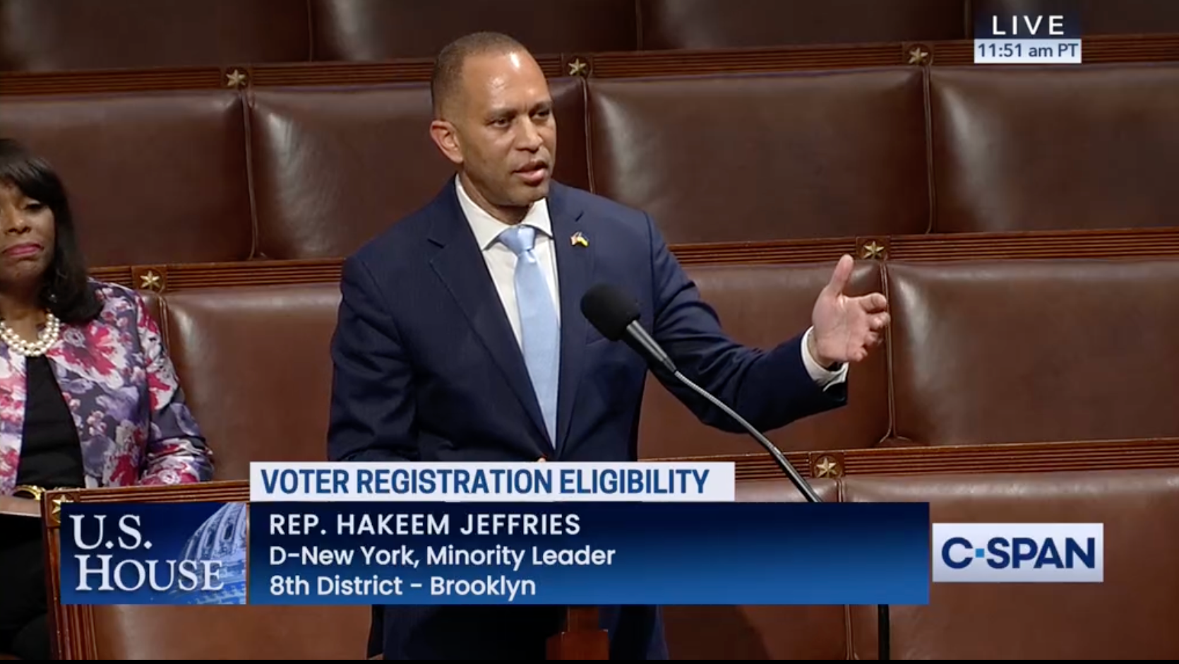 Leader Jeffries speaks on the House Floor, an arm extended to his right. The chryon reads Voter Registration Eligibility.